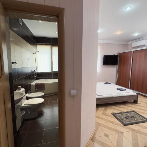 a bathroom with two toilets a sink and a bed at Mini Hotel Leon in Lalovo
