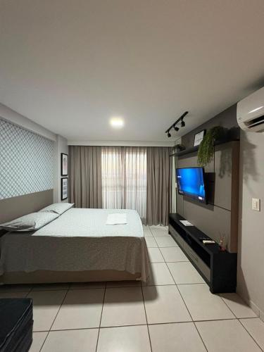 a bedroom with a bed and a flat screen tv at West Flat - BarretoStays 02 in Mossoró