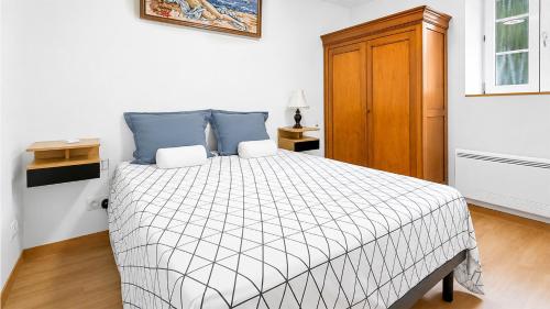 a bedroom with a bed and a wooden cabinet at T2 Cosy - Proche Dijon -Terrasse - Parking in Pichanges