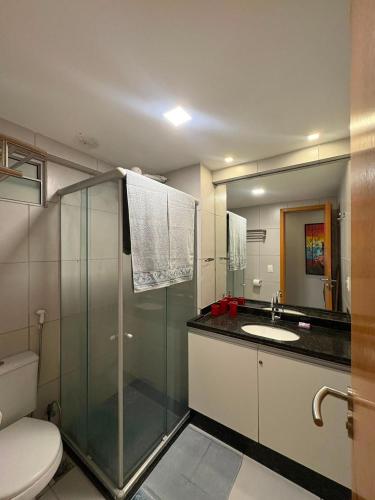 a bathroom with a shower and a toilet and a sink at West Flat - BarretoStays 02 in Mossoró