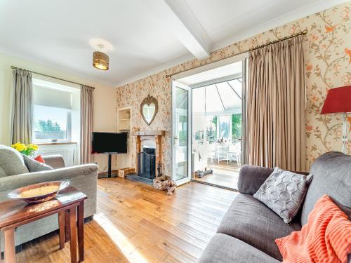 a living room with a couch and a tv at Torr Cottage in Dalrymple