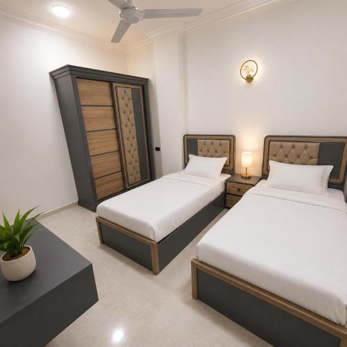 a bedroom with two beds and a clock on the wall at Sunrise View K8 Apartments in Hurghada