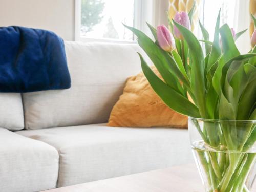 a vase with flowers on a table in front of a couch at Marlow Lodge in Hyssington