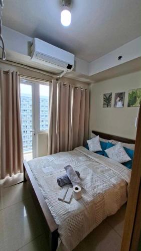 a bedroom with a bed with two towels on it at Accommodating Place in Manila