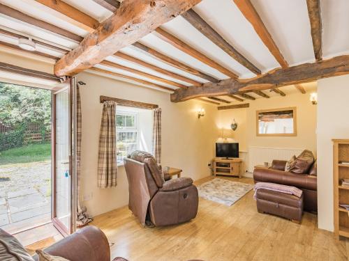 a living room with a couch and a tv at Bluebell Cottage - Ukc6676 in Bettws-yn-Rhôs