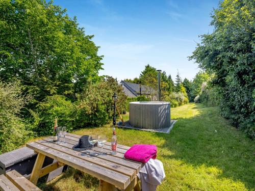 a wooden picnic table with a bottle of wine on it at Primrose Cottage - Ukc6679 in Bettws-yn-Rhôs