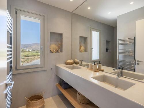a bathroom with two sinks and a large mirror at Villa Bema - Quietness and Beach access in Molos Parou