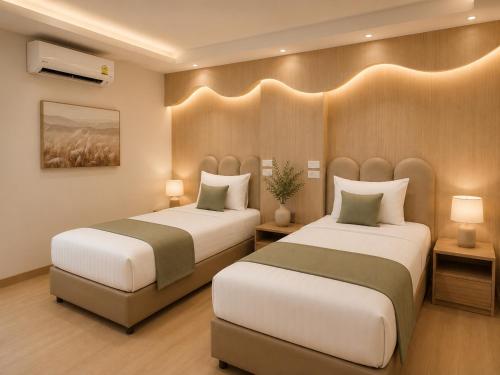 a hotel room with two beds and two lamps at Chanaplace Lanna in Chiang Mai