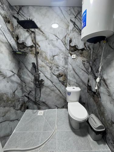 a bathroom with a toilet and a water tank at Guest House Kel-Kel in Bokonbayevo