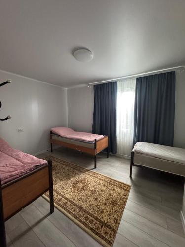 a room with two beds and a window at Guest House Kel-Kel in Bokonbayevo