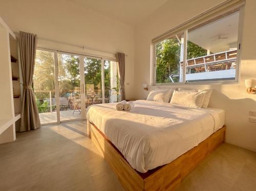 a bedroom with a large bed and a large window at Villa Leo in Ban Madua Wan
