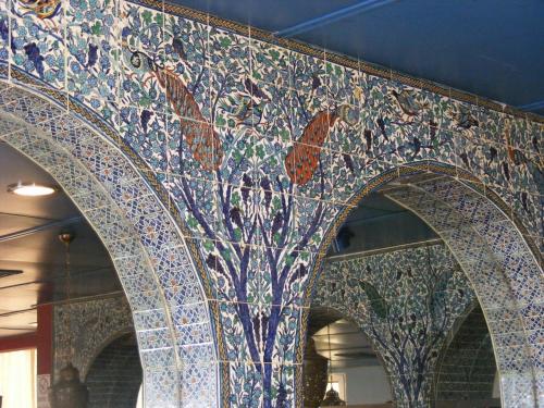 a mosaic wall in a building with arrows and butterflies at Seven Arches Hotel in Jerusalem