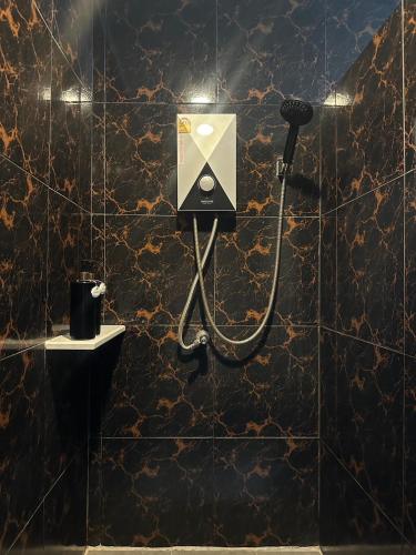 a bathroom with a soap dispenser on a wall at Love Box Resort in Samutprakarn