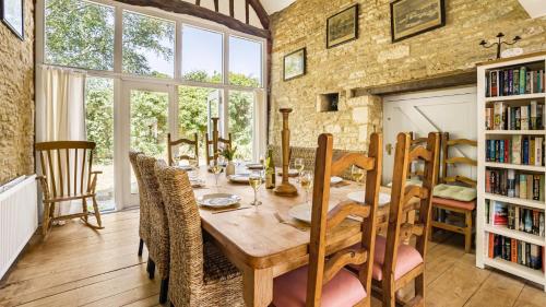 a dining room with a wooden table and chairs at Butts Farm in Cirencester