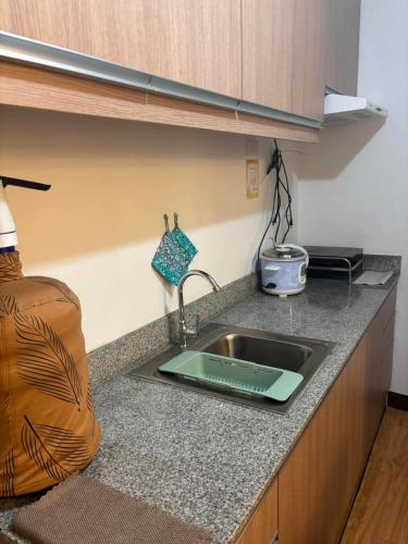 a kitchen counter with a sink with a ipad on it at Arezzo Place in Davao City
