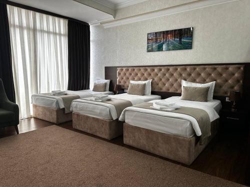 a hotel room with two beds and a large window at Grand Turon Plaza Hotel in Tashkent
