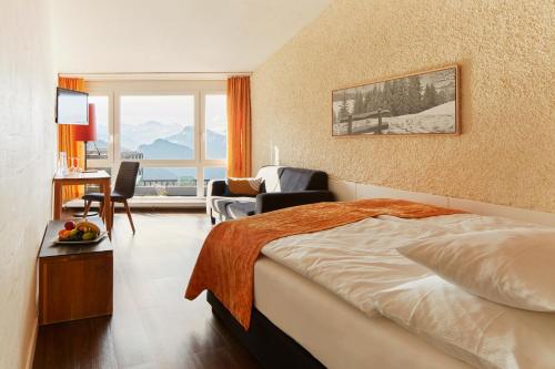 a hotel room with a bed and a living room at Rigi Kaltbad Swiss Quality Hotel in Rigi Kaltbad