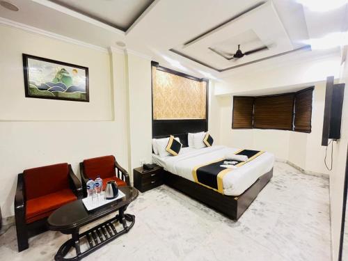 a bedroom with a bed and a desk and a chair at Hotel Dharma Heights - Sector 11 Noida in Noida