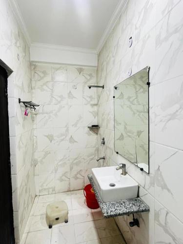 a white bathroom with a sink and a mirror at Hotel Dharma Heights - Sector 11 Noida in Noida