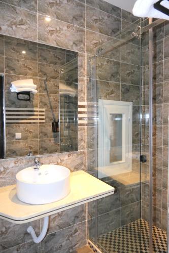 a bathroom with a sink and a glass shower at Hotel Hacienda in Martil