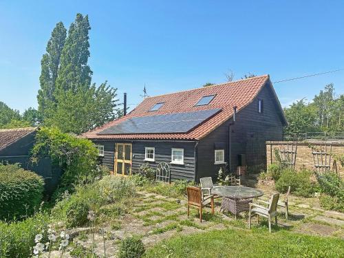 a house with solar panels on the roof at Munns Farm Barn in Earls Colne