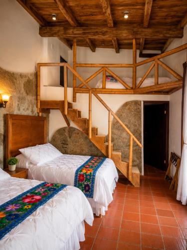a bedroom with two beds and a staircase at La Peña Hotel Boutique & SPA in Cuetzalán del Progreso