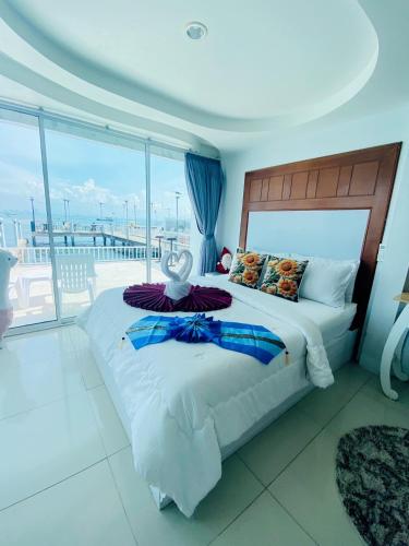 a bedroom with a bed with a view of the ocean at ลุงชีพบ้านพัก เกาะล้านLoongcheeb House in Ko Larn