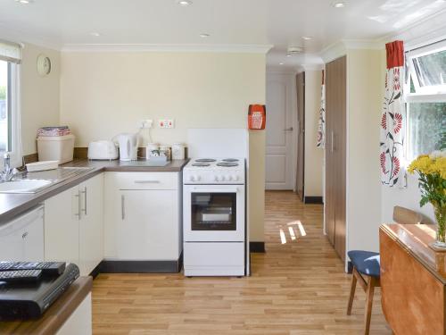 a kitchen with white appliances and a wooden floor at Halcyon - Uk12696 in Stalham