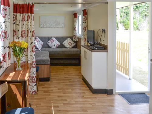 a living room with a couch and a television at Halcyon - Uk12696 in Stalham