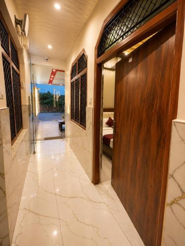 a hallway with a wooden door in a house at Hotel R-A-M-A-N-S-H GRAND INN - Beside Ram Mandir Ayodhya 96,7000,2101 in Ayodhya