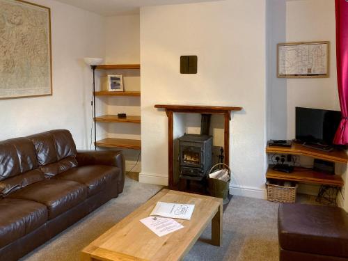 a living room with a couch and a wood stove at Croft Cottage in Braithwaite