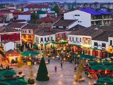 a view of a town at night with people at Rise And Shine Rooms Korca in Korçë