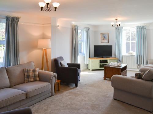 a living room with two couches and a tv at Riverside - Ukc2296 in Stalham