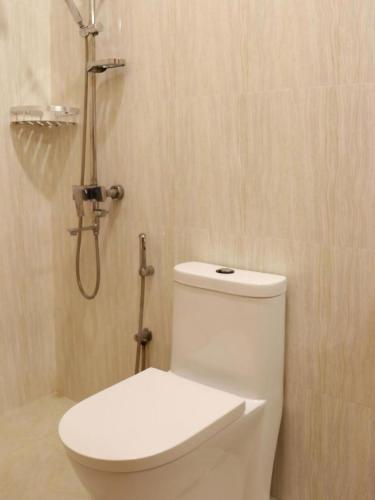 a white toilet in a bathroom with a shower at Ocean Stay & Dive in Fenfushi