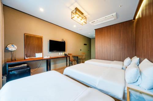 a hotel room with two beds and a desk at Benikea Hotel Kakao in Seoul