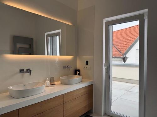 a bathroom with two sinks and a large mirror at Aparthotel Othello in Dingolfing