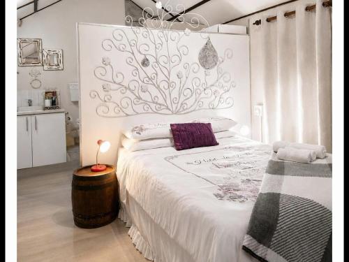 a white bedroom with a large bed and a chandelier at Art Guest House in Lutzville