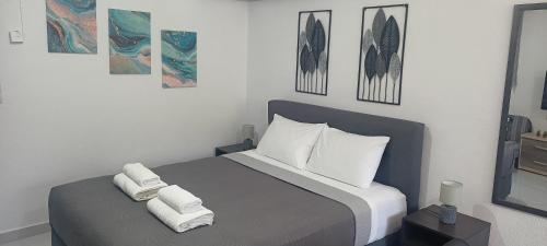 ein Schlafzimmer mit einem Bett, auf dem Handtücher liegen in der Unterkunft Lemon Suites in Mytilini