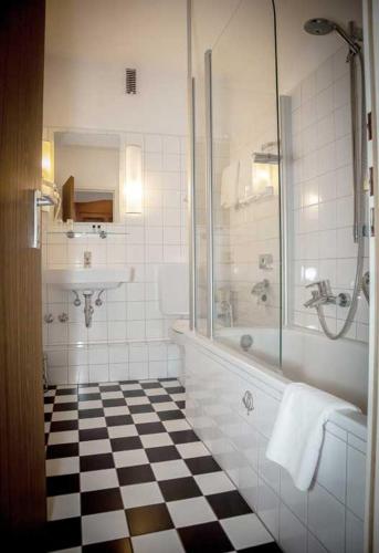 a bathroom with a glass shower and a sink at Hotel zur Post in Lüdinghausen
