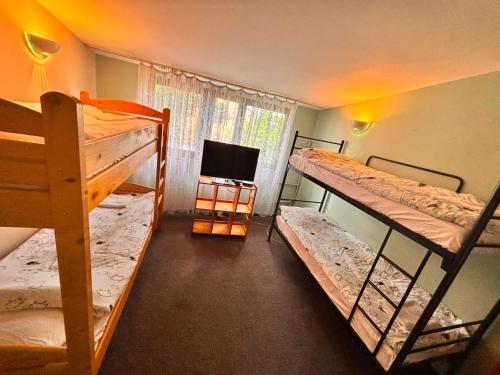 a room with three bunk beds and a television at Dwór Złoty Bażant in Olsztyn