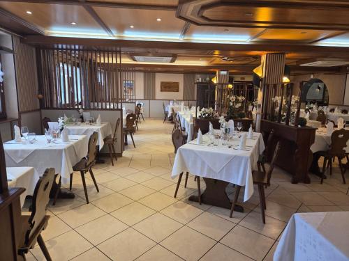 a restaurant with tables and chairs with white table cloth at Hôtel Restaurant AU SOLEIL in Wahlbach