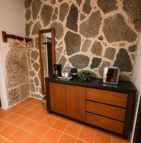 a counter in a room with a stone wall at La Peña Hotel Boutique & SPA in Cuetzalán del Progreso