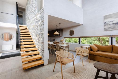a living room with a staircase and a couch and a table at Casas Punta Costanera in Pichilemu