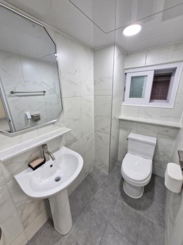 a bathroom with a sink and a toilet and a mirror at Minimo Stay in Pyeongtaek