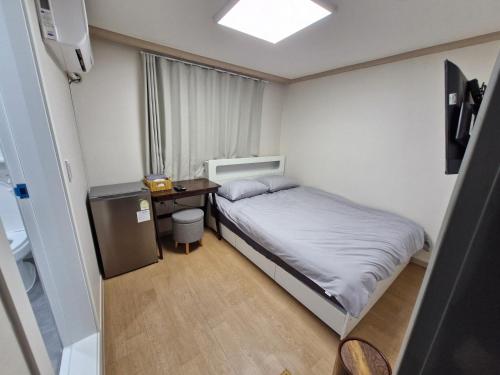 a small bedroom with a bed and a desk at Minimo Stay in Pyeongtaek