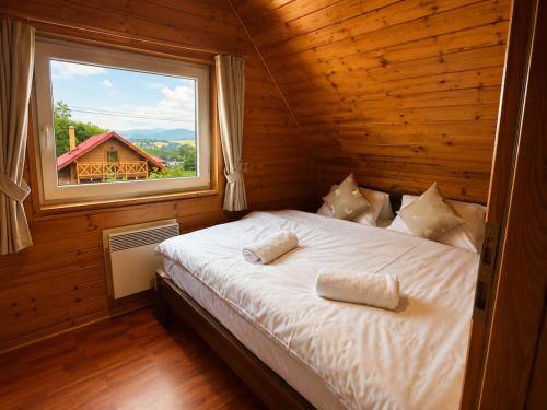 a bed in a wooden room with a window at Chata Medvedík in Turík