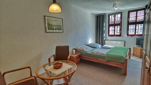 a bedroom with a bed and a table and chairs at Alte Posthalterei in Stolberg