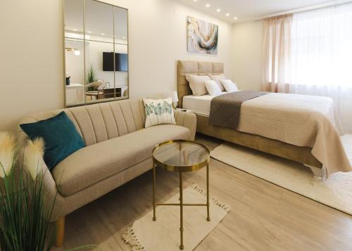 a living room with a bed and a couch at apartman STUDIO ELEGANCE in Bečej