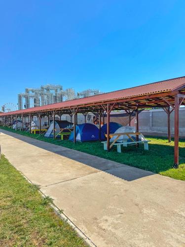 a long row of tents on the grass at Relax by the Sea Camping next to Nibiru in Costinesti
