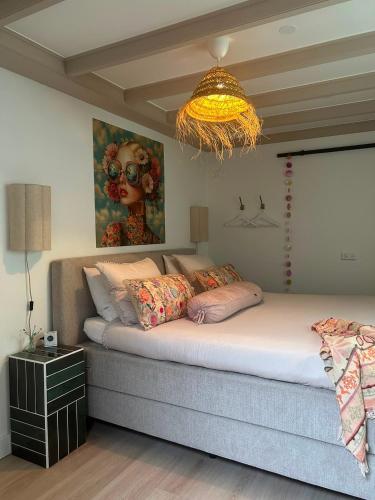 a bedroom with a large bed with a painting on the wall at Bed & Breakfast Betuws Genieten in Tiel